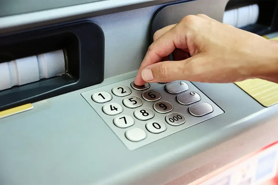banking customer entering pin number at an ATM